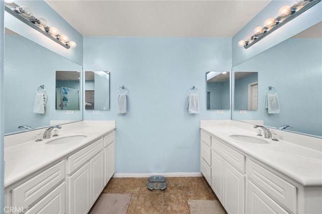 full bathroom with two vanities and baseboards