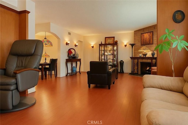 1600 N Hobart Blvd Unit 16, Los Angeles, CA 90027 - living room featuring arched walkways, hardwood / wood-style floors, and a large fireplace