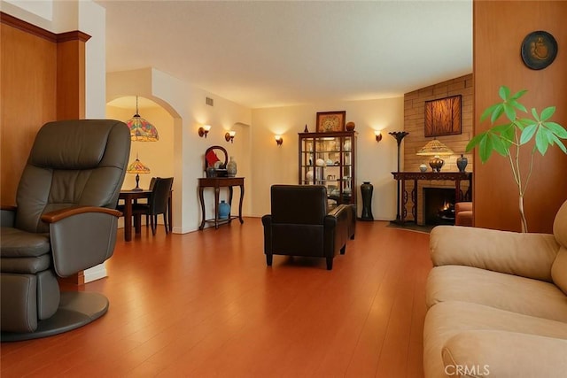 1600 N Hobart Blvd Unit 16, Los Angeles, CA 90027 - living area with arched walkways, hardwood / wood-style flooring, and a fireplace