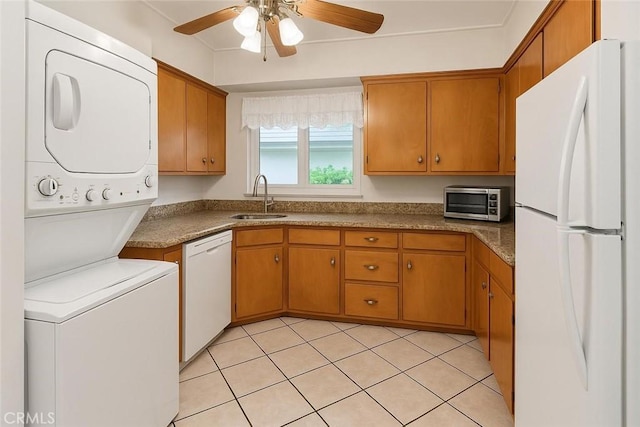 1600 N Hobart Blvd Unit 16, Los Angeles, CA 90027 - kitchen with white appliances, estacked washer and dryer, ceiling fan, brown cabinets, and light tile patterned floors