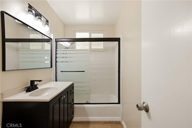 1808 W Palm Dr, West Covina, CA 91790 - bathroom with vanity, wood finished floors, bath / shower combo with glass door, and baseboards