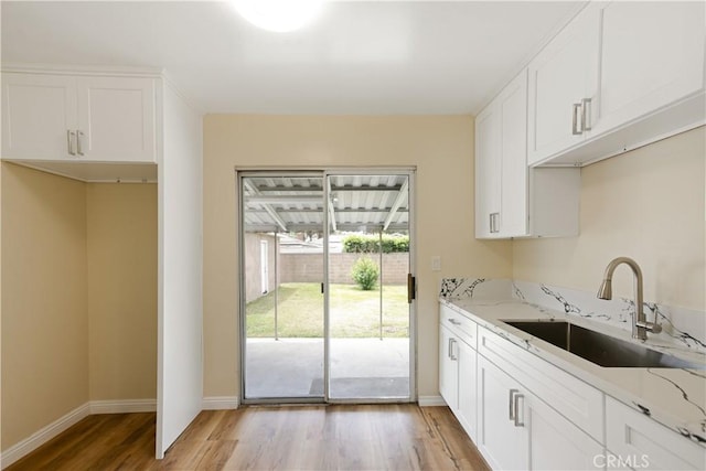 1808 W Palm Dr, West Covina, CA 91790 - kitchen with a sink, light wood-type flooring, light stone counters, and white cabinetry