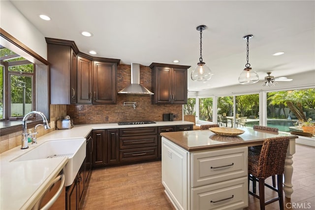 10356 Claire Ave, Porter Ranch, CA 91326 - kitchen with wall chimney exhaust hood, recessed lighting, backsplash, a ceiling fan, and dark brown cabinets