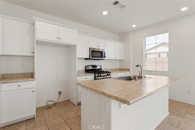17210 Pioneer Way, San Bernardino, CA 92407 - kitchen with stainless steel appliances, white cabinetry, a center island with sink, light tile patterned flooring, and recessed lighting