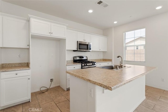 17210 Pioneer Way, San Bernardino, CA 92407 - kitchen with appliances with stainless steel finishes, a kitchen island with sink, white cabinets, light tile patterned floors, and recessed lighting