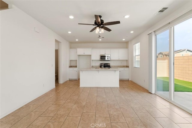 17210 Pioneer Way, San Bernardino, CA 92407 - kitchen with appliances with stainless steel finishes, recessed lighting, white cabinets, a ceiling fan, and an island with sink