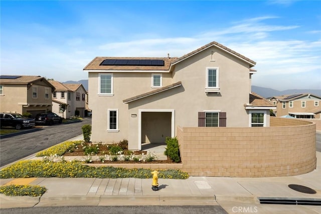 17210 Pioneer Way, San Bernardino, CA 92407 - view of front facade with roof mounted solar panels, stucco siding, and a residential view