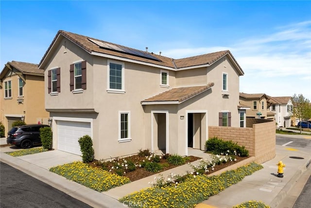 17210 Pioneer Way, San Bernardino, CA 92407 - view of front of home featuring roof mounted solar panels, stucco siding, an attached garage, and concrete driveway
