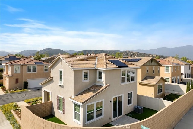 17210 Pioneer Way, San Bernardino, CA 92407 - back of house featuring stucco siding, a mountain view, a fenced backyard, a residential view, and a garage