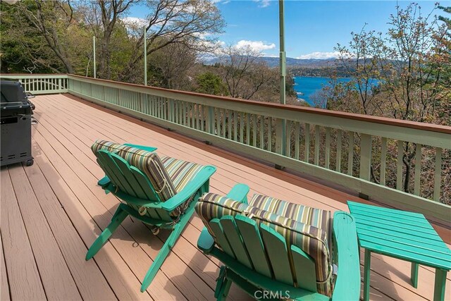 wooden deck featuring a grill and a water and mountain view