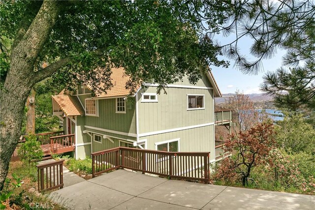 back of property featuring a patio and a wooden deck