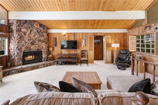 living area with carpet flooring, wood walls, plenty of natural light, wood ceiling, and a stone fireplace