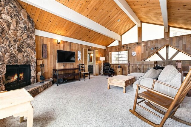 living room featuring wood walls, wooden ceiling, a stone fireplace, and carpet floors