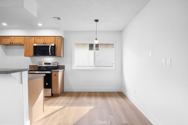 18103 Camino Bello Unit 4, Rowland Heights, CA 91748 - kitchen featuring appliances with stainless steel finishes, light wood-style floors, baseboards, brown cabinets, and a textured ceiling