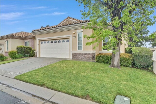 440 Brooklawn Dr, Banning, CA 92220 - view of front of property with driveway, a front yard, a garage, stucco siding, and stone siding