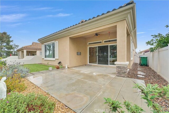 440 Brooklawn Dr, Banning, CA 92220 - rear view of property with ceiling fan, a fenced backyard, a patio, stucco siding, and a tile roof