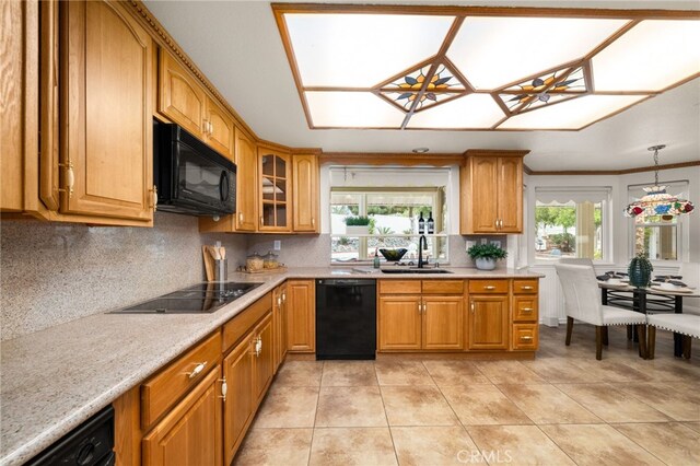kitchen with black appliances, a sink, decorative backsplash, and brown cabinetry