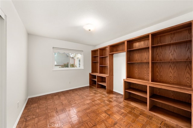 unfurnished room with baseboards