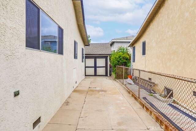 1677 252nd St, Harbor City, CA 90710 - view of home's exterior with stucco siding, roof with shingles, and a patio