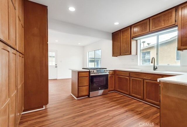 1677 252nd St, Harbor City, CA 90710 - kitchen featuring stainless steel range with gas stovetop, light wood finished floors, brown cabinets, healthy amount of natural light, and recessed lighting