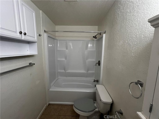 full bathroom with tile patterned flooring, toilet, baseboards,  shower combination, and a textured ceiling
