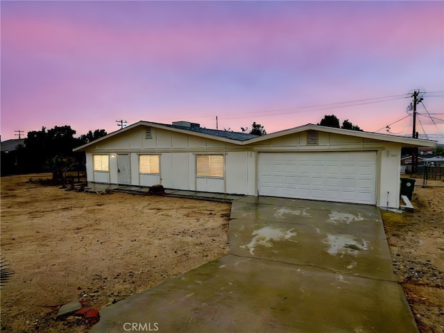 single story home with an attached garage, board and batten siding, and driveway