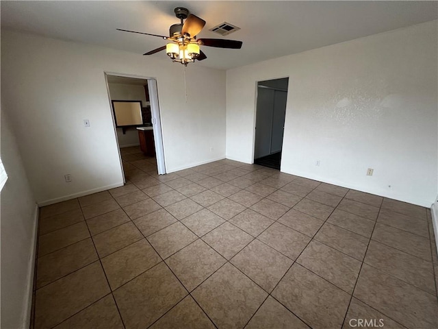 tiled empty room featuring ceiling fan