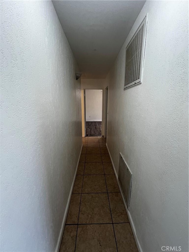 hall with tile patterned floors and baseboards