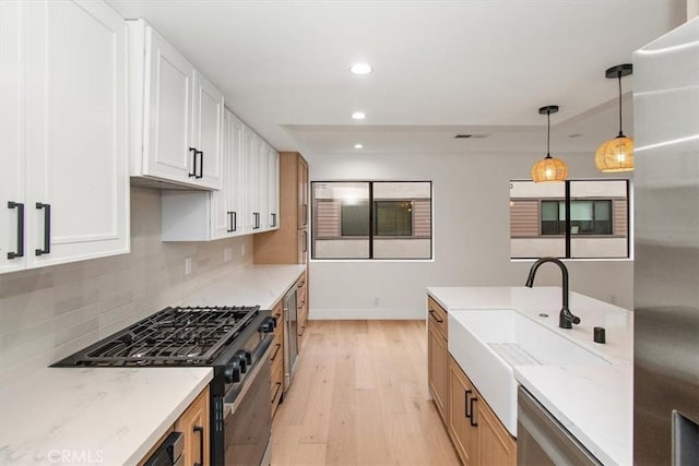 13044 Mindanao Way Unit 3, Marina Del Rey, CA 90292 - kitchen with gas range oven, a sink, light wood-style floors, recessed lighting, and light stone counters