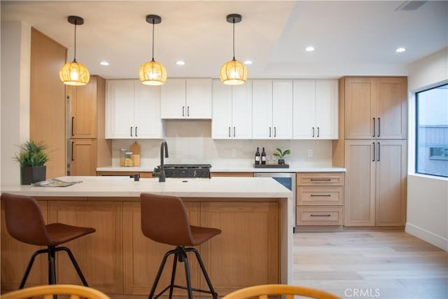 13044 Mindanao Way Unit 3, Marina Del Rey, CA 90292 - kitchen with light wood-style floors, light countertops, recessed lighting, a breakfast bar area, and decorative light fixtures