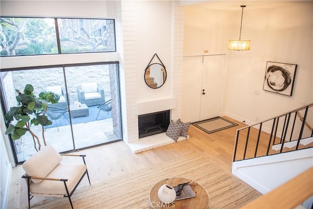 13044 Mindanao Way Unit 3, Marina Del Rey, CA 90292 - unfurnished living room featuring wood finished floors, stairs, a brick fireplace, and a chandelier