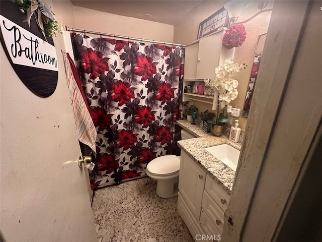 full bathroom with vanity, speckle patterned floor, toilet, and a shower with shower curtain