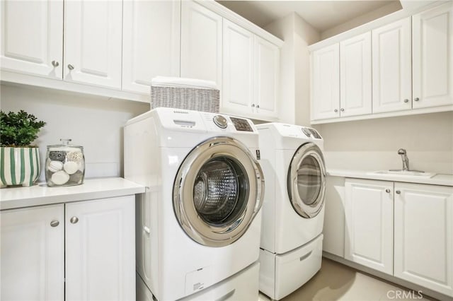 washroom with cabinet space and washing machine and dryer