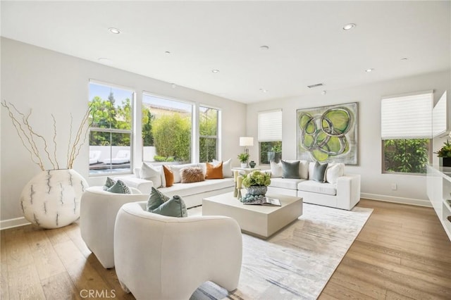 living room featuring baseboards, light wood-style floors, and recessed lighting