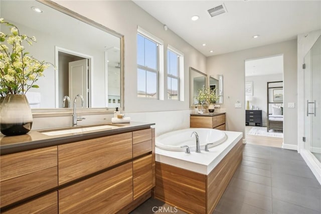 bathroom with two vanities, a bath, recessed lighting, and tile patterned floors