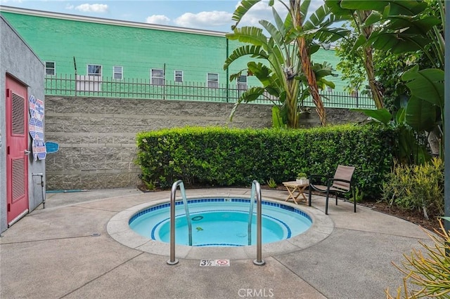 view of swimming pool with a hot tub, fence, and a patio