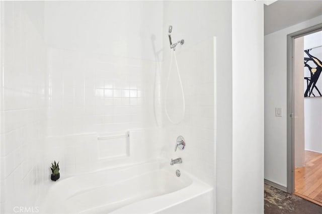 bathroom with bathtub / shower combination and baseboards