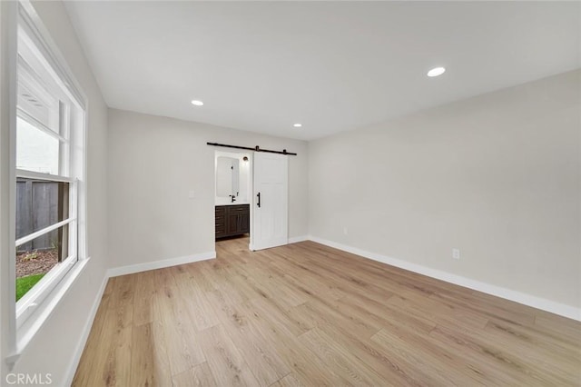 212 La Paloma, San Clemente, CA 92672 - empty room featuring a barn door, plenty of natural light, light wood-type flooring, baseboards, and recessed lighting