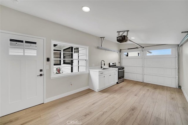 212 La Paloma, San Clemente, CA 92672 - garage with a garage door opener, a sink, baseboards, and recessed lighting