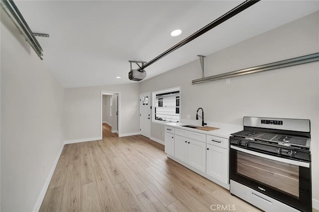 212 La Paloma, San Clemente, CA 92672 - kitchen featuring gas stove, a sink, white cabinetry, baseboards, and light wood-type flooring