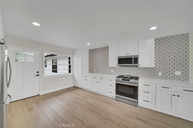212 La Paloma, San Clemente, CA 92672 - kitchen featuring stainless steel appliances, white cabinetry, light countertops, light wood-type flooring, and backsplash