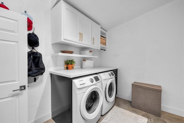 clothes washing area featuring cabinet space, separate washer and dryer, baseboards, and light tile patterned floors