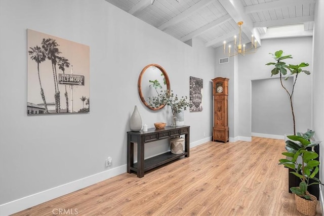 hall featuring a chandelier, wooden ceiling, beam ceiling, baseboards, and wood finished floors