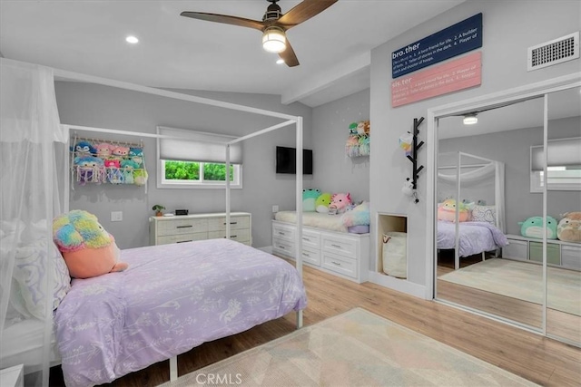bedroom with lofted ceiling, light wood-style floors, and a ceiling fan