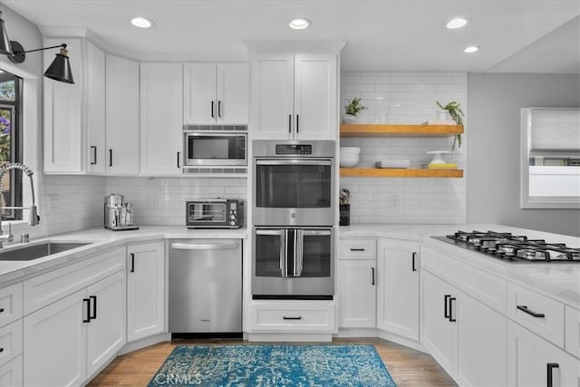kitchen featuring stainless steel appliances, a sink, backsplash, recessed lighting, and healthy amount of natural light