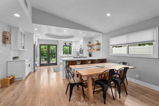 dining area featuring lofted ceiling, light wood-style flooring, recessed lighting, and baseboards