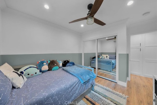 bedroom with crown molding, wood finished floors, recessed lighting, a closet, and a ceiling fan