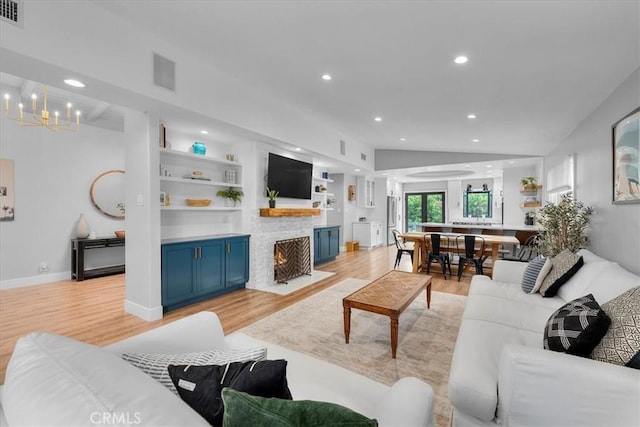 living room with light wood-style floors, a chandelier, recessed lighting, a fireplace with flush hearth, and baseboards