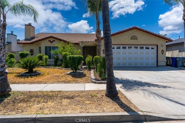 379 Edan Ct, Merced, CA 95341 - mediterranean / spanish-style home featuring an attached garage, driveway, a tiled roof, and stucco siding