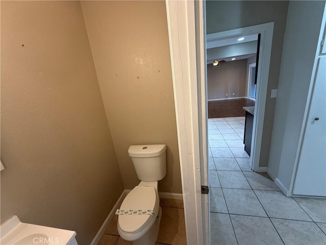 bathroom with toilet, tile patterned flooring, and baseboards